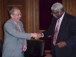 Liang Jianming and Marius St. Rose shake hands on the agreement