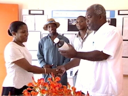 Joan Norville handing over agricultural products to Roseau Combined  Principal - Sylvester Phillip