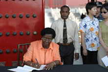 GG signs Visitor's Book as ADC Captain Cyril Saltibus and security personnel look on
