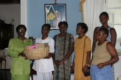 Governor General presents supplies to Nurse Lawrence, District Nurse for the health centres of Anse-La-Raye, Roseau and Jacmel. Some health aids witness the presentation