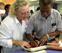 Dunston signs a phone book for a fan