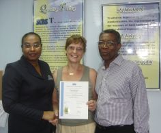 Head of Certification, Betty Combie presents certificate to Penny and Thompson Charles, owners of The Farmhouse