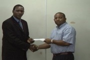 Minister for Sports Hon. Lenard Montoute presents a cheque to a recipient
