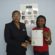 Head of Certification, Betty Combie issues certificate to Joanne Arthur of J.I. Agro Processing.